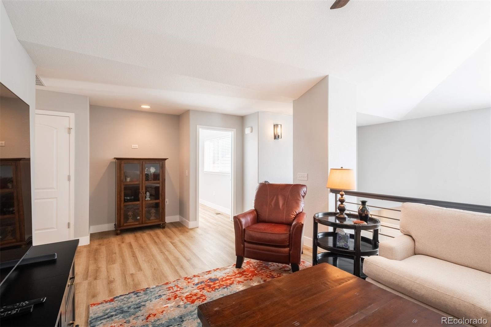 8555 Gold Peak Drive, Unit B Highlands Ranch, CO 80130 - Photo 20 of 38 a bedroom with furniture and a wooden floor