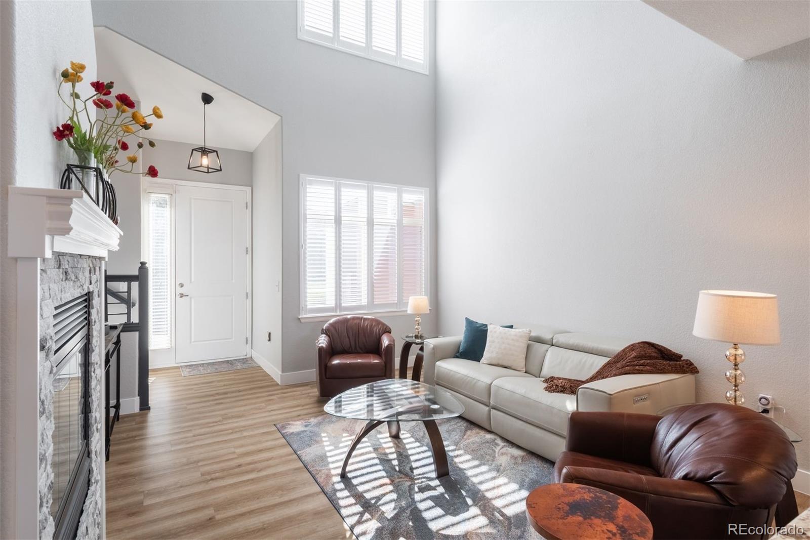 8555 Gold Peak Drive, Unit B Highlands Ranch, CO 80130 - Photo 2 of 38 a living room with furniture a fireplace and a flat screen tv