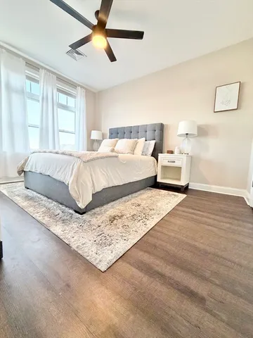 a living room with a bed furniture and next to a window