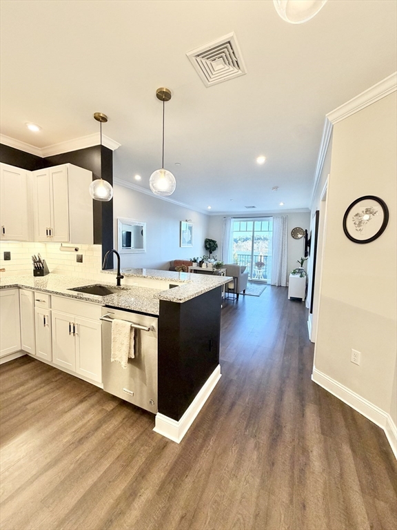 69 Foundry Street, Unit 416 Wakefield, MA 01880 - Photo 4 of 21 a kitchen with stainless steel appliances granite countertop a sink a stove and a wooden floors