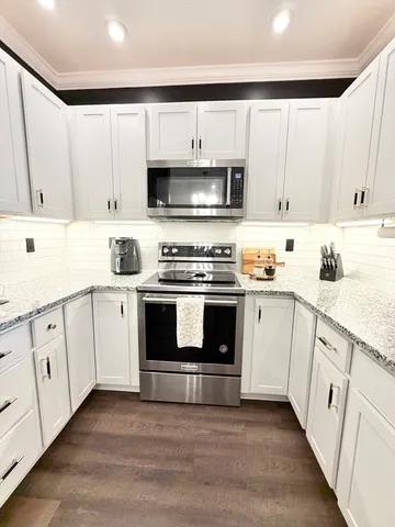 a kitchen with white cabinets and white appliances