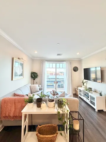 a living room with furniture a flat screen tv and a large window