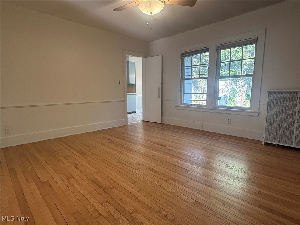1979 Staunton Road Cleveland, OH 44118 - Photo 7 of 37 Empty room featuring light wood-type flooring, radiator, and a ceiling fan