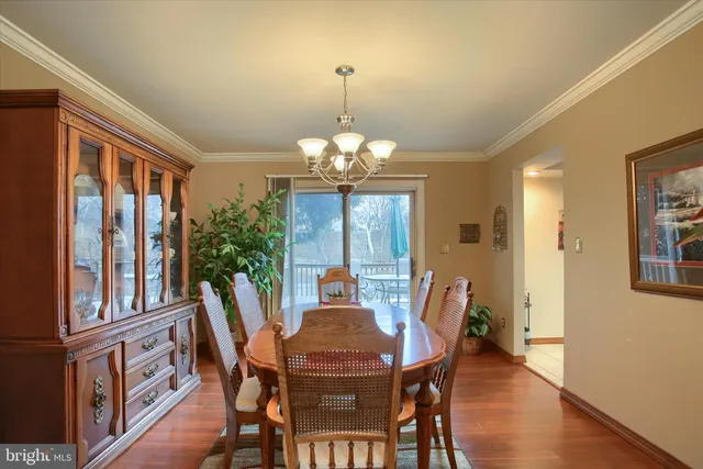 a view of a dining room with furniture a chandelier and wooden floor