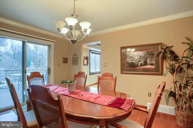 a view of a dining room with furniture a chandelier and wooden floor