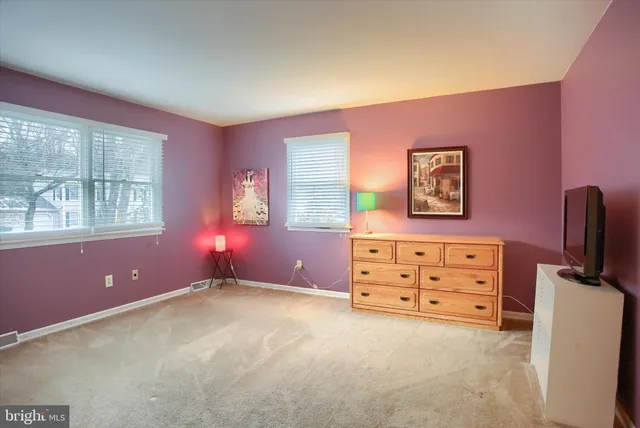 an empty room with windows cabinet and flat screen tv