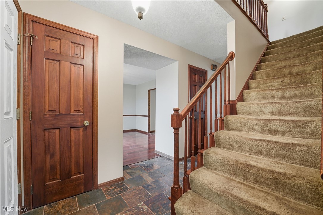 11710 Butternut Road Chardon, OH 44024 - Photo 22 of 48 Foyer featuring dark stone finish floors and stairway