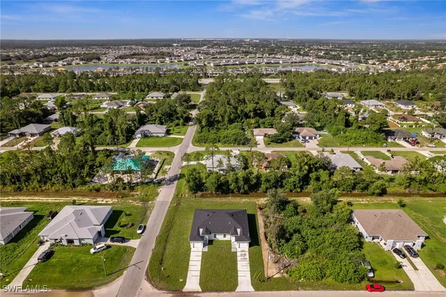 an aerial view of residential houses with outdoor space and swimming pool