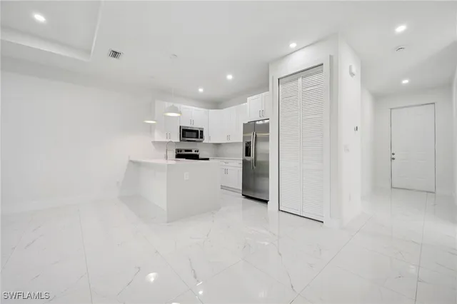 a kitchen with stainless steel appliances a refrigerator sink and microwave