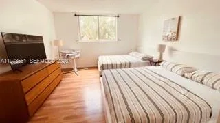 a bedroom with bed and a flat screen tv