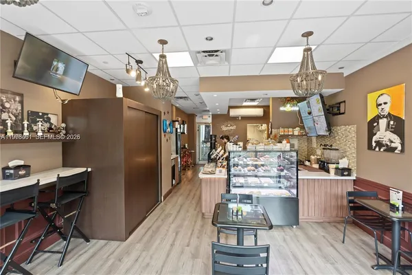 a kitchen with stainless steel appliances granite countertop a refrigerator oven stove dining table and chairs with wooden floor