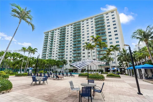 a view of a tall building with a table and chairs under an umbrella