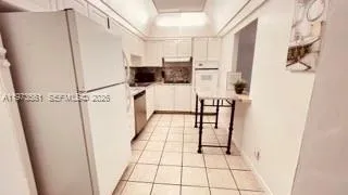 a view of kitchen with furniture and refrigerator