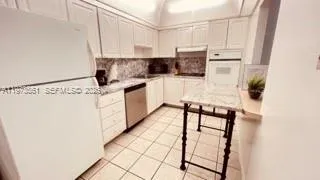 a kitchen with white cabinets and white appliances