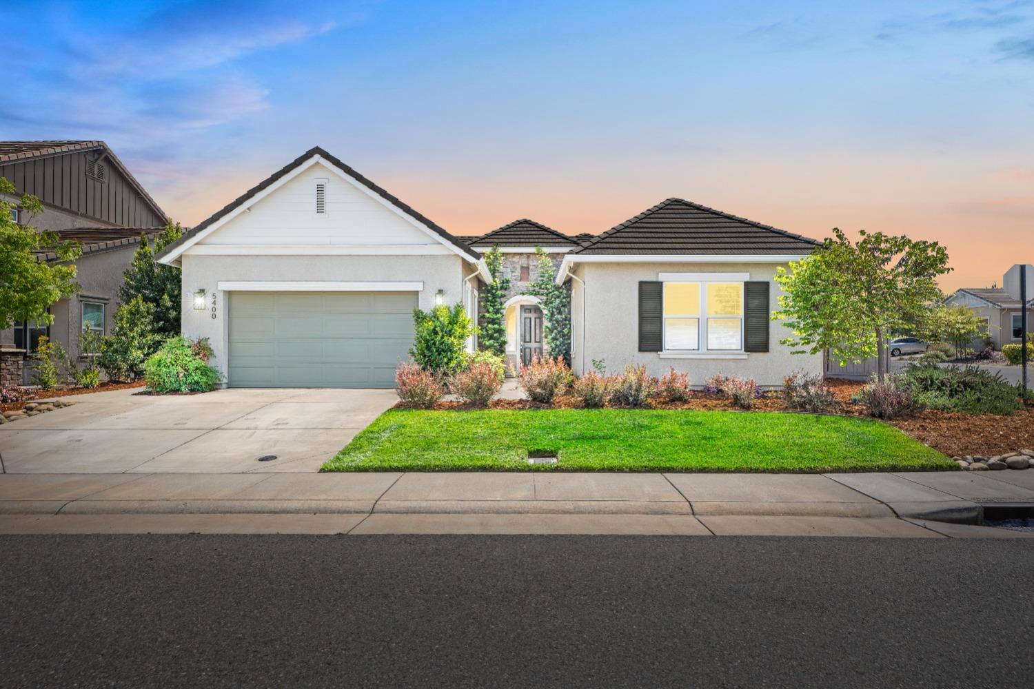a front view of a house with a yard and garage