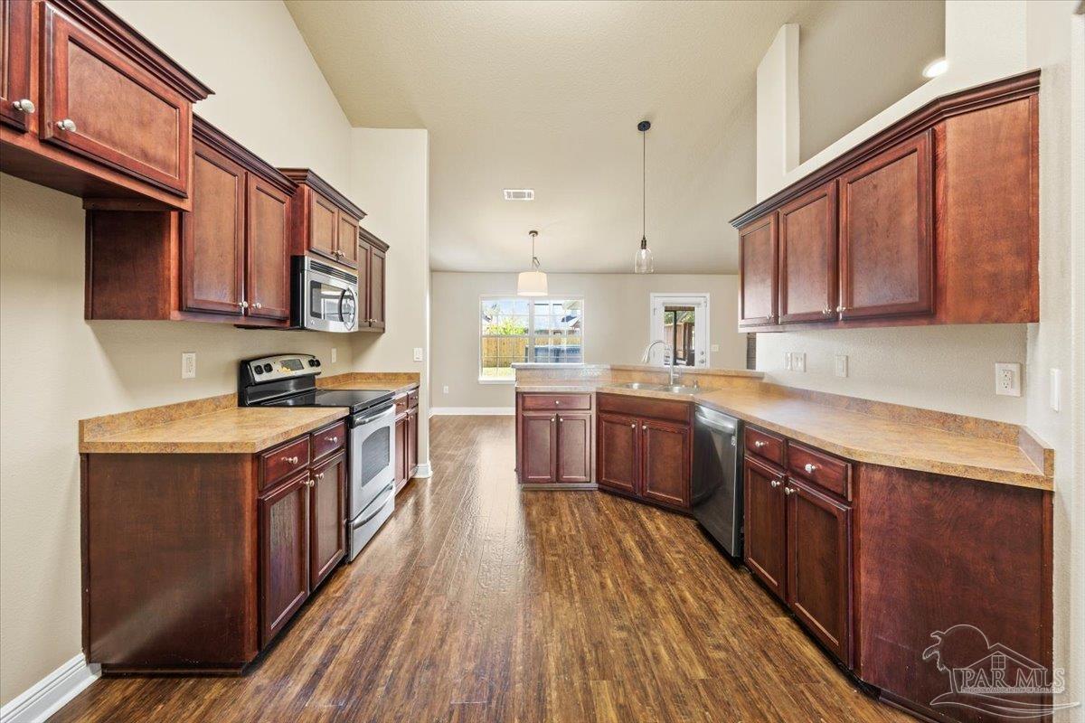 4015 Berry Circle Pace, FL 32571 - Photo 14 of 48 a kitchen with stainless steel appliances granite countertop a stove a sink dishwasher and a refrigerator with wooden cabinets