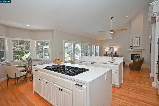 a kitchen with a stove a sink a refrigerator and wooden floor