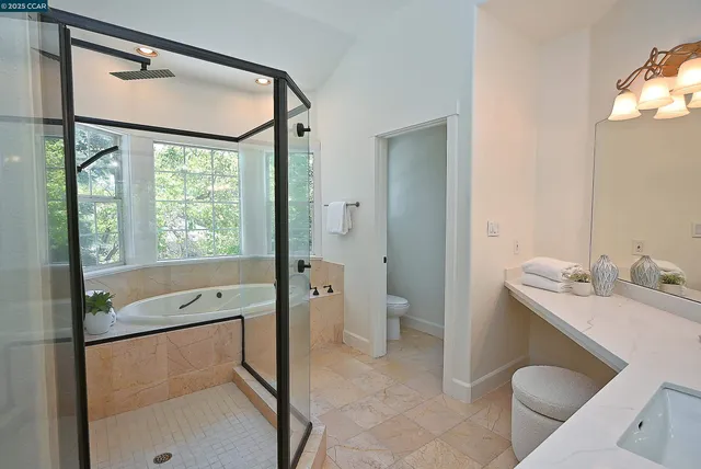 a bathroom with a granite countertop sink toilet and shower