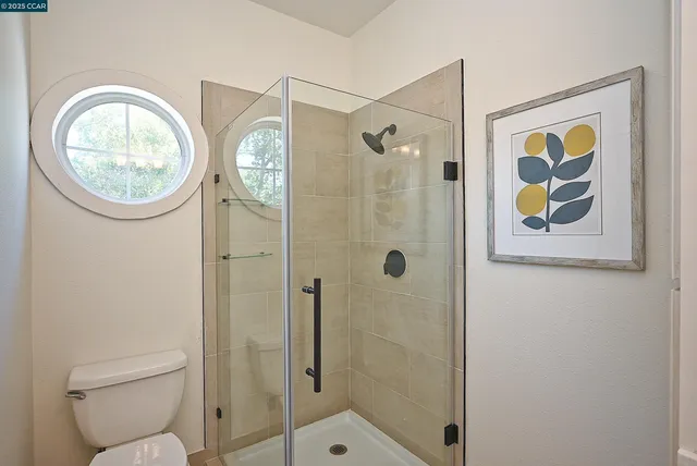 a bathroom with a toilet and a shower