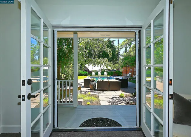 a view of a wooden house with a yard and sitting area