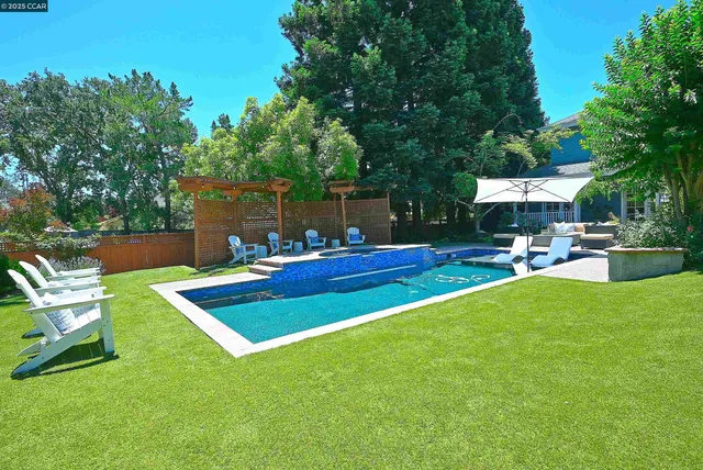 an aerial view of a house with a yard and swimming pool