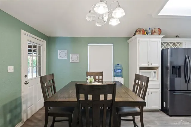 a view of a dining room with furniture a chandelier and wooden floor