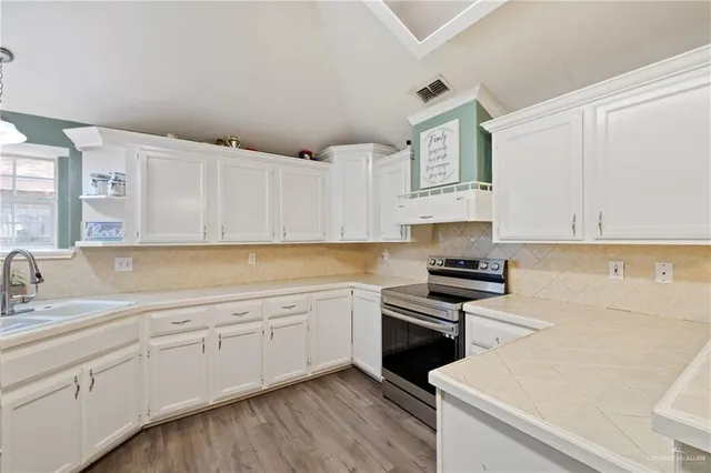a kitchen with granite countertop white cabinets and appliances