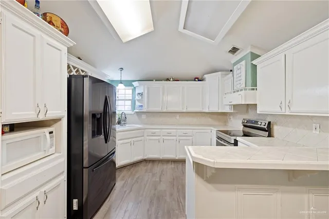 a kitchen with a sink appliances and cabinets