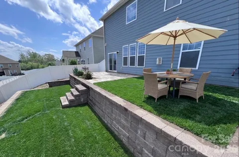 a view of a house with backyard and sitting area