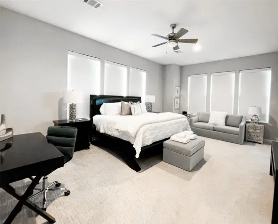 a bedroom with a bed couches and a table with projector