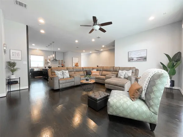 a living room with furniture kitchen view and a flat screen tv