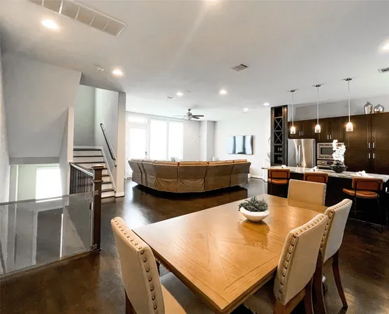 a living room with stainless steel appliances kitchen island granite countertop furniture and a wooden floor