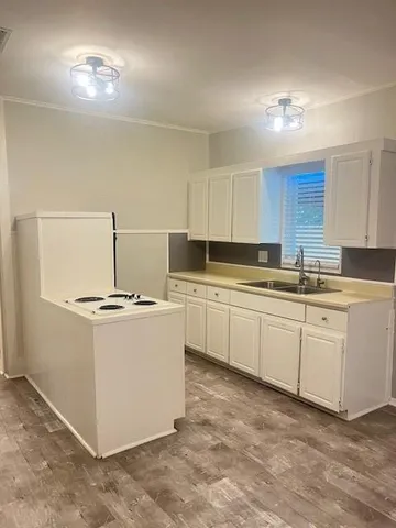 a kitchen with granite countertop a sink and white cabinets