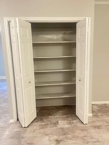 a view of walk in closet with empty racks