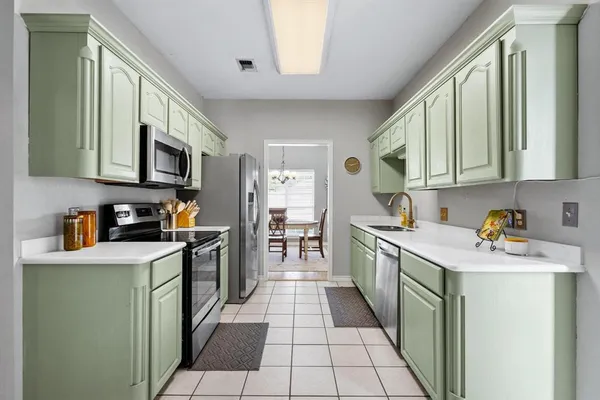 a kitchen with a sink cabinets and stainless steel appliances