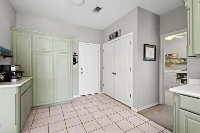 a view of a kitchen with a sink and dishwasher a refrigerator with white cabinets