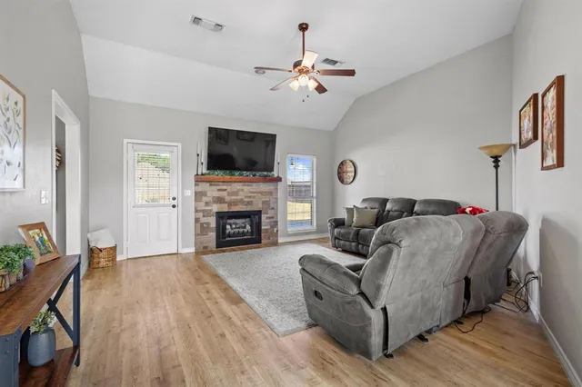 a living room with furniture a flat screen tv and a fireplace