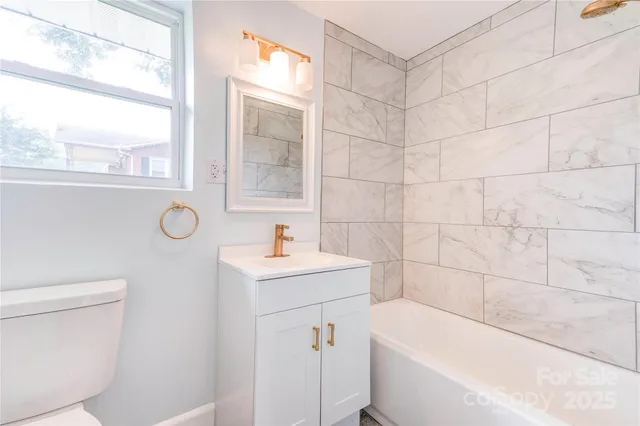 a bathroom with a bathtub a sink a toilet and a window