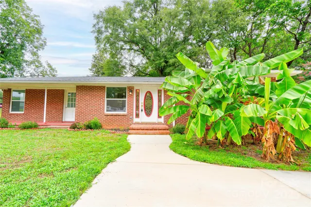 a front view of a house with a garden and yard