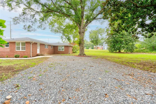 a view of a house with a yard and tree s