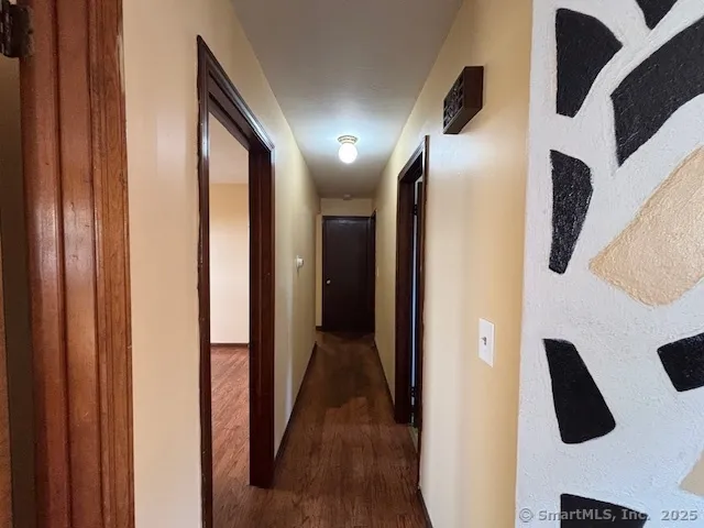 a view of a hallway with stainless steel appliances and cabinets