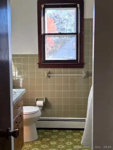a bathroom with a toilet a sink and a window