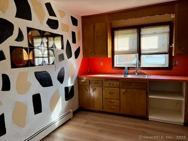 a kitchen with stainless steel appliances kitchen island a table and a window