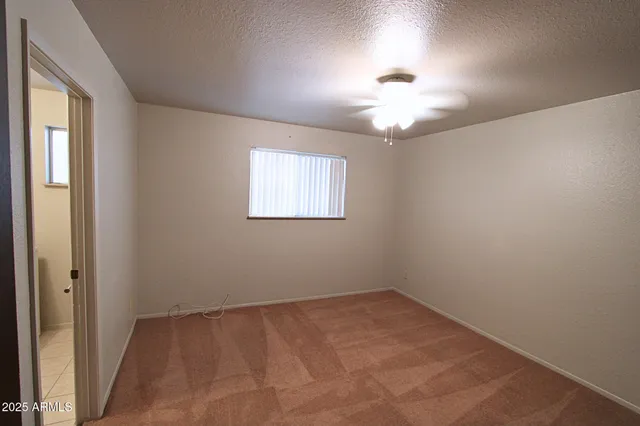 an empty room with closet and windows