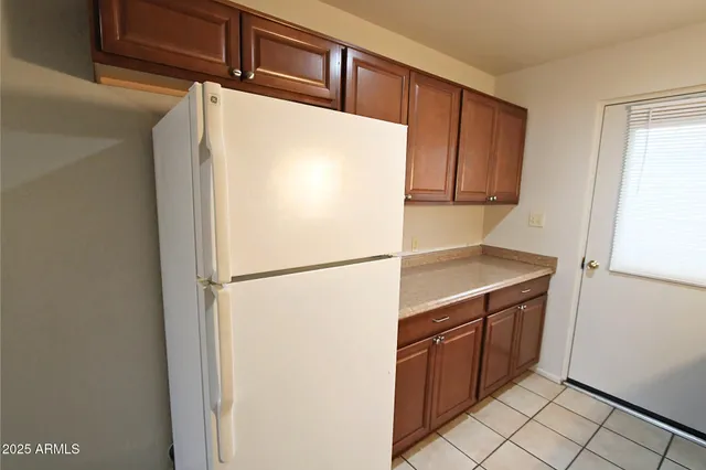 a white refrigerator freezer and a stove sitting inside of a kitchen