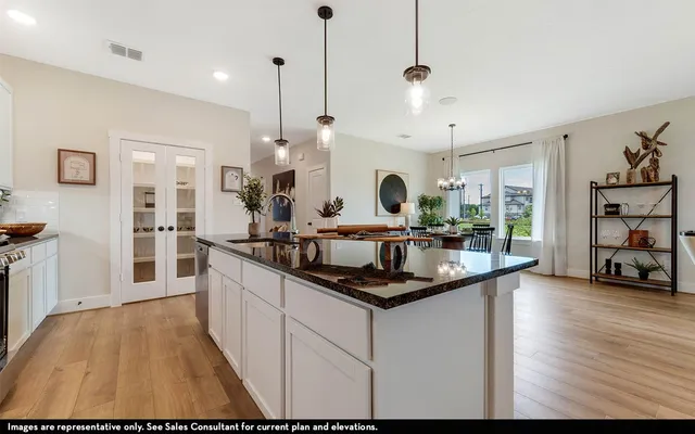 a kitchen with stainless steel appliances granite countertop a stove and a wooden floor