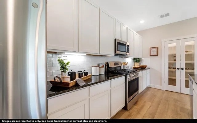 a kitchen with stainless steel appliances granite countertop a stove a sink and a refrigerator