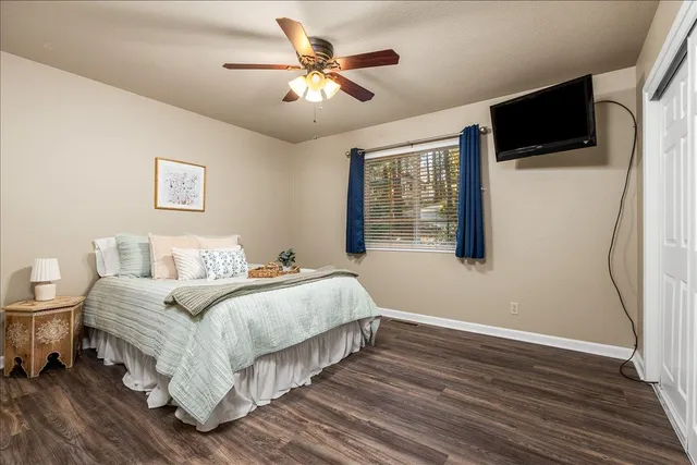 a spacious bedroom with a bed and a flat screen tv