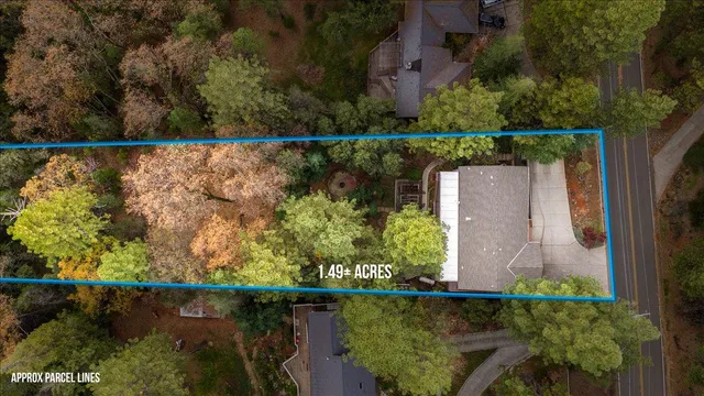 an aerial view of a house with a yard and lake view