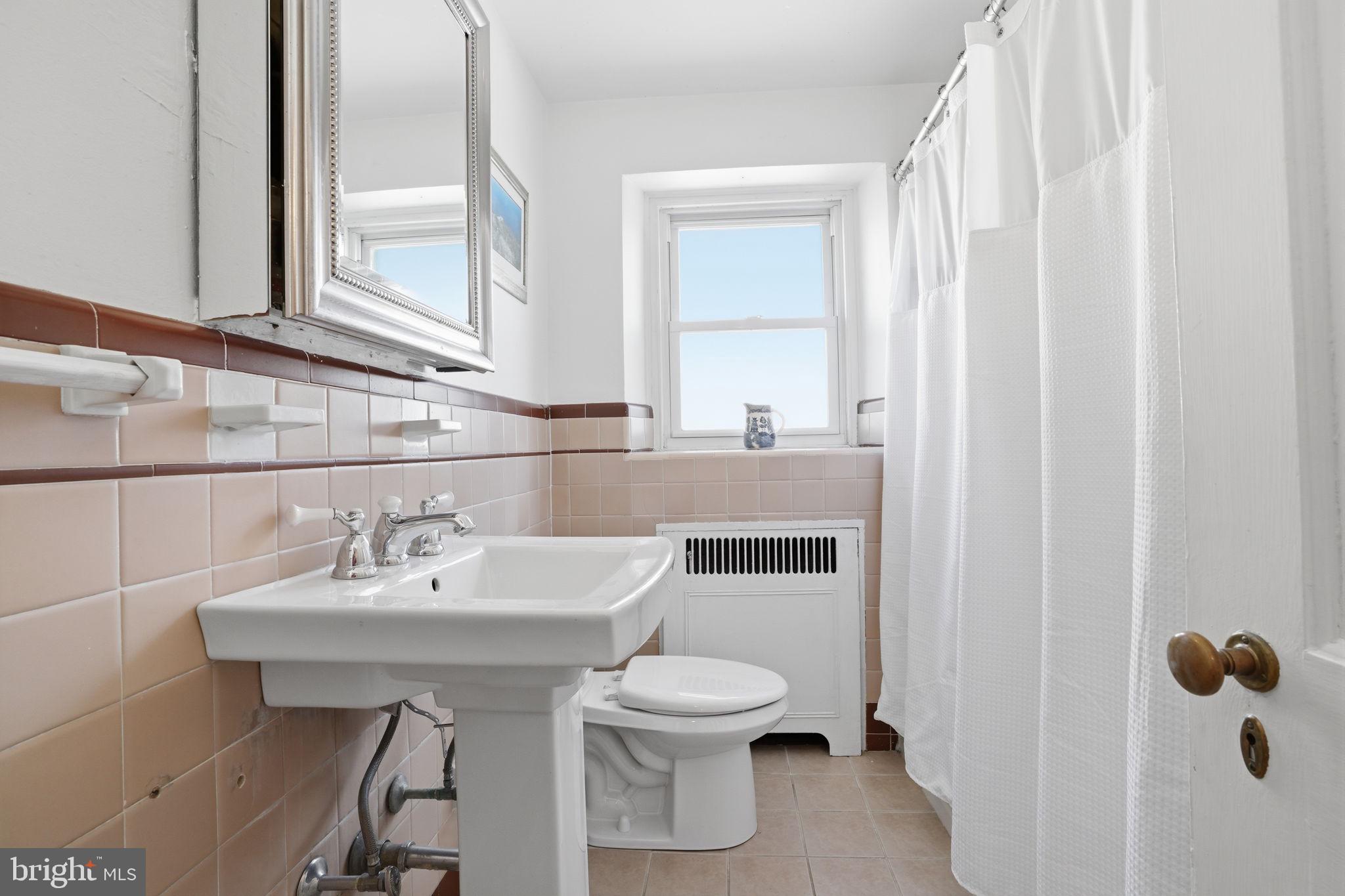 7791 Spring Avenue Elkins Park, PA 19027 - Photo 19 of 33 a bathroom with a sink a toilet and mirror
